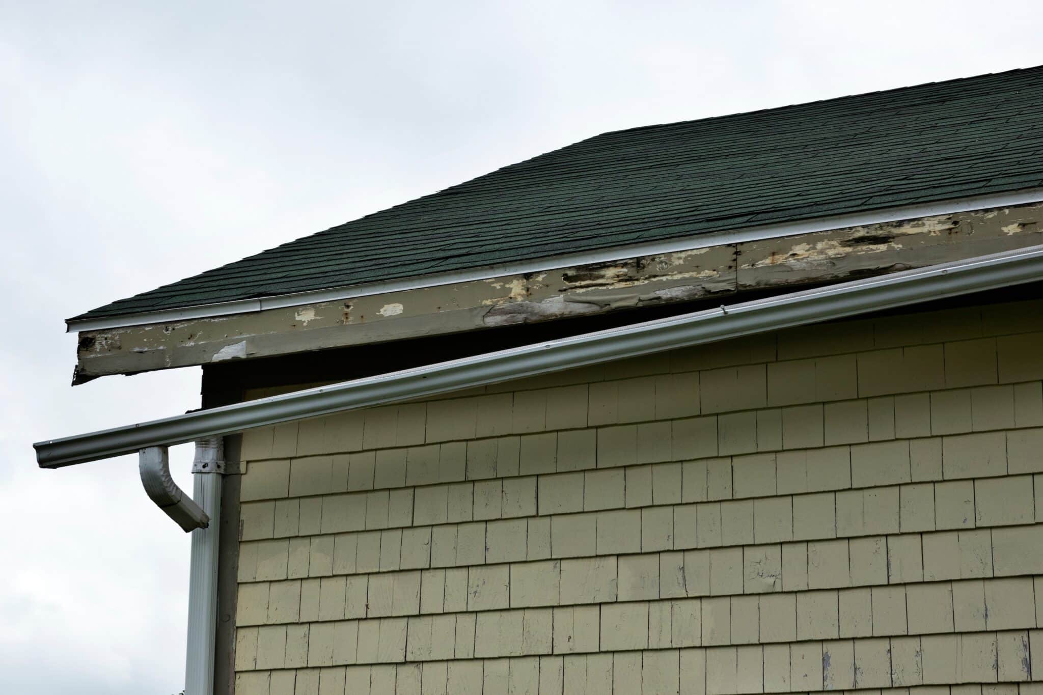 A badly damaged gutter on a house side